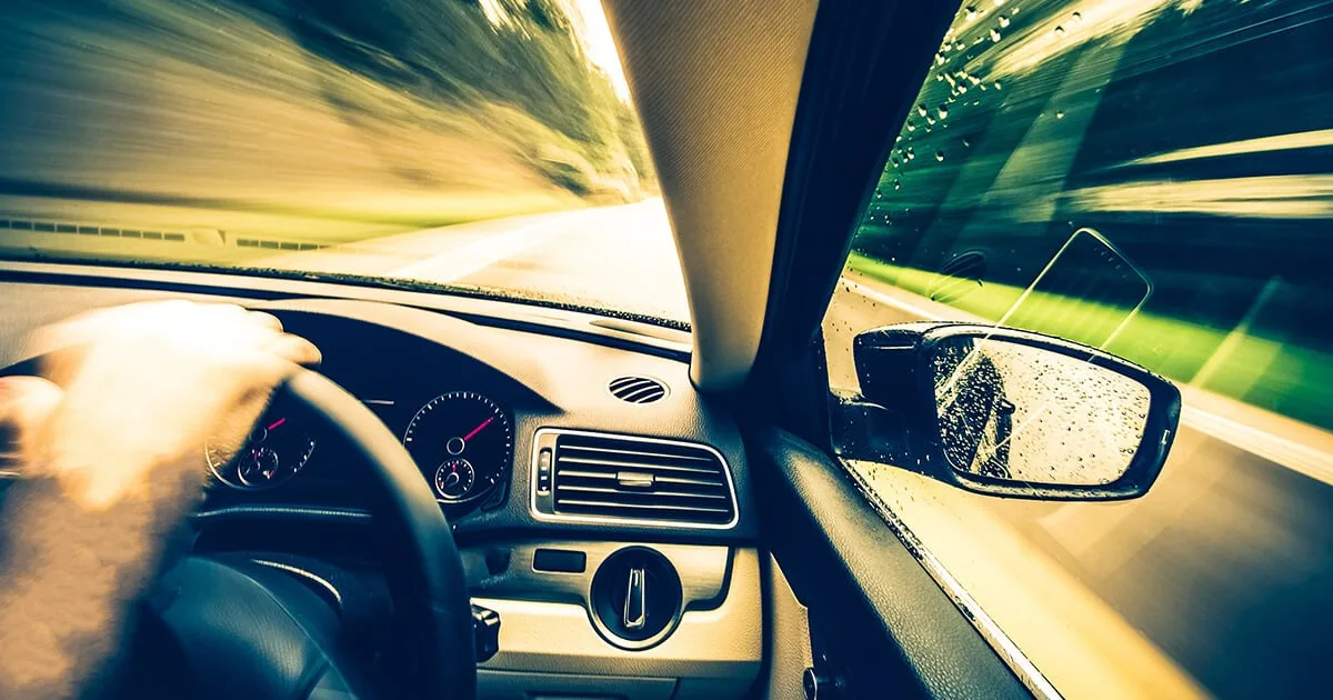 Vue du tableau de bord d'une voiture pendant un trajet, compteur de vitesse allumé