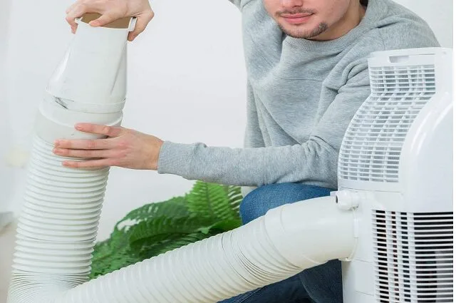 Gaine souple d'un climatiseur mobile passant par l'ouverture d'une fenêtre