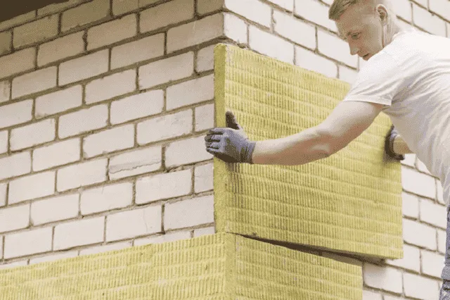 Pose de panneaux isolants sur la façade d'une maison en rénovation