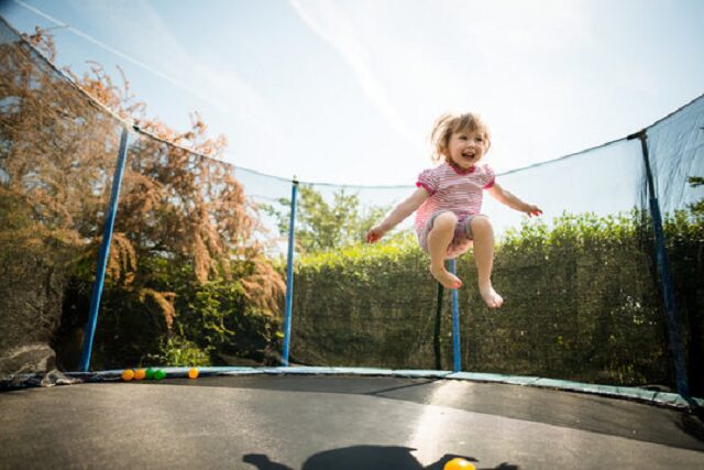 petite fille joue dans un trampoline