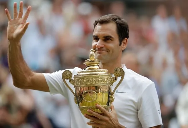 Roger Federer en pleine frappe de revers lors d'un match sur gazon