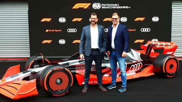Monoplace de Formule 1 aux couleurs Sauber devant un logo Audi