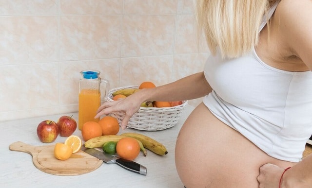 Femme enceinte avec fruits.