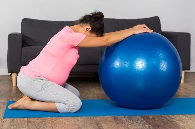 Femme enceinte en tenue de sport pendant une séance d'exercices au sol