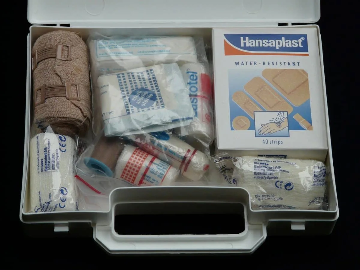 Sac de secours ouvert avec eau, lampe de poche, trousse de soins et vivres